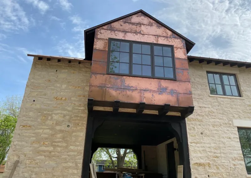 Copper metal panel facade on a stone building for Skylight Installation in Woods Creek